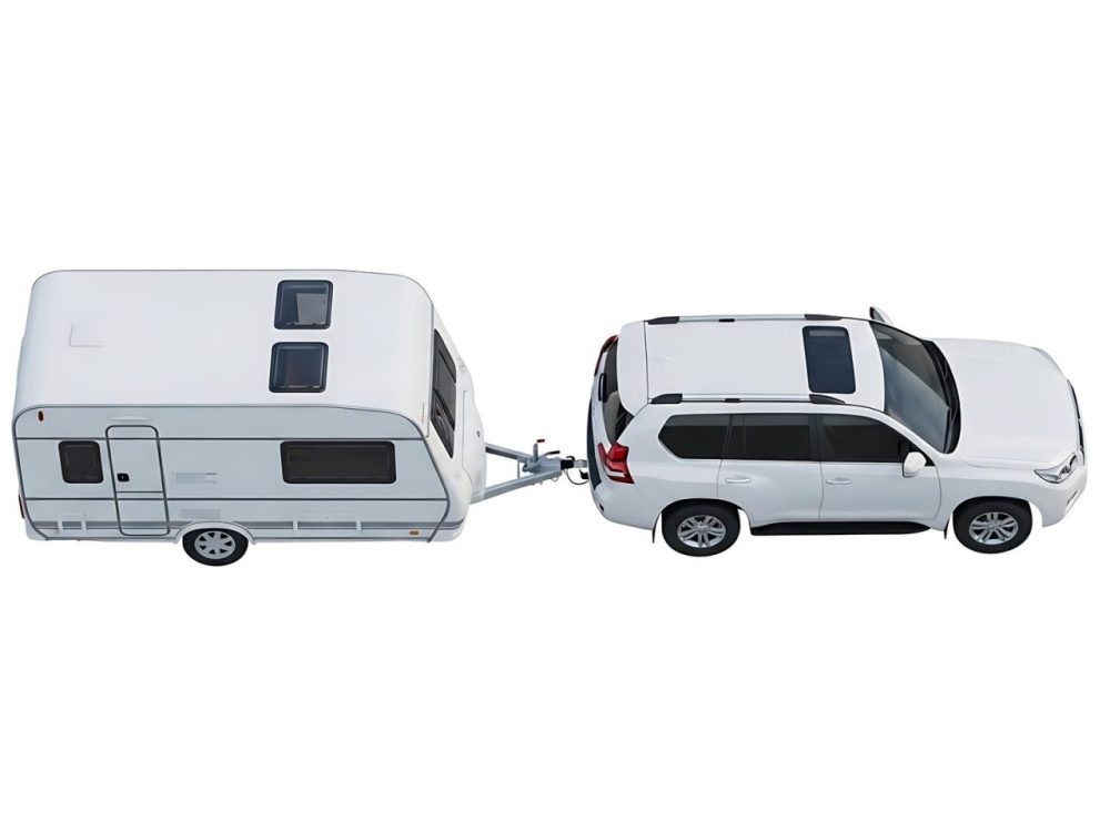 Une voiture tracte une caravane sur une route de campagne.
